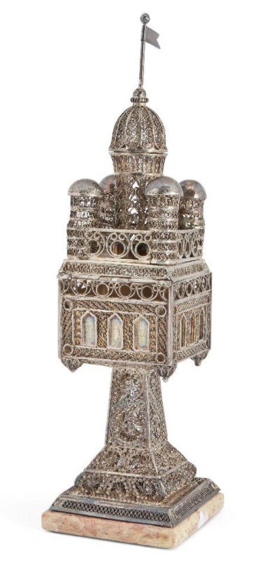  A silver filigree spice tower of architectural form, by the Bezalel school, Jerusalem, c.1920  Another item from by the Bezalel school in Jerusalem, that sold well was a silver filigree spice tower of architectural form, c.1920. Estimated at £2,000- £4,000, the spice tower went on to make £5,750 at auction. This highly collectable piece has five domed turrets and a flag engraved 'Jerusalem' in Hebrew to hinged cover, the square foot applied on one side with Hebrew words reading 'Bezalel Jerusalem' and stamped with an Austrian import mark for 1901-21. 
