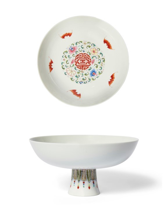 Lot 35 on offer is a fine quality Chinese porcelain famille rose 'flowers and wufu' tazza, Qianlong mark and of the period. The shallow bowl surmounting a slightly flaring elongated foot is decorated to the interior with a painted shou character enclosed by a band of flowering blossom amidst scrolling leafy stems and iron-red wufu around the cavetto. The underside is decorated with radiating iron-red ruyi-head lappets, above a border of pendent green and yellow plantain leaves suspending beaded tassels. Underglaze is a blue six-character Qianlong seal mark on the interior of the foot. The tazza which measures 17cm in diameter and 8.8cm high comes with an estimate of £8,000-12,000. A similar example can be found in the Qing Court Collection, Palace Museum, Beijing.