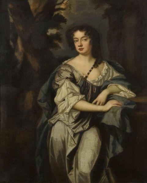 Studio of Sir Peter Lely, British 1618-1680- Portrait of Miss Elizabeth Lewis, standing three-quarter length, wearing a green cloak fixed by a jewelled clasp in a landscape setting; oil on canvas